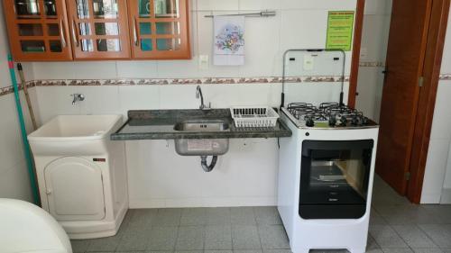 a small kitchen with a stove and a sink at PRAIA 4 ILHAS Apartamento 1 Quarto a 50M da Praia in Bombinhas