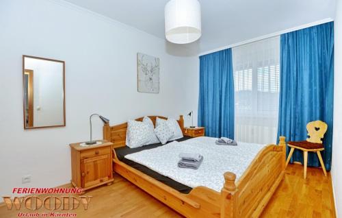 sypialnia z dużym łóżkiem z niebieskimi zasłonami w obiekcie Ferienwohnung Woody w mieście Sankt Urban