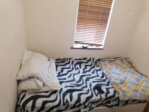 a bed with a zebra print sheets and a window at Vob Property 76 in Hither Green