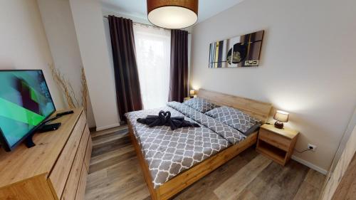 um quarto com uma cama e uma televisão de ecrã plano em Apartmán Tobias, PRIMO, Starý Smokovec em Starý Smokovec