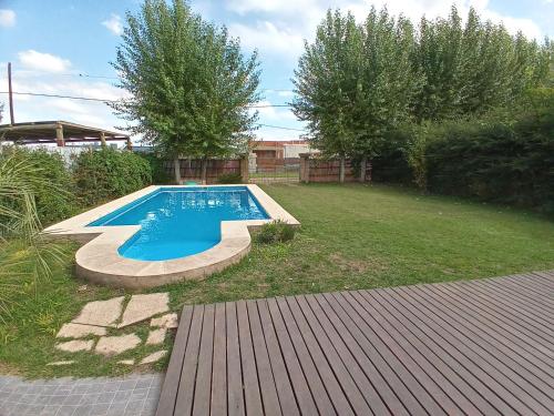 a swimming pool in a yard with a wooden deck at Casa quinta Camino al Sol in Junín