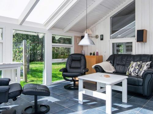 ein Wohnzimmer mit einem Sofa, Stühlen und einem Tisch in der Unterkunft 6 person holiday home in Ulfborg in Ulfborg