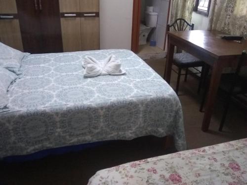 Cette chambre comprend deux lits, un bureau et une table. dans l'établissement Hospedaje Marita, à Lima