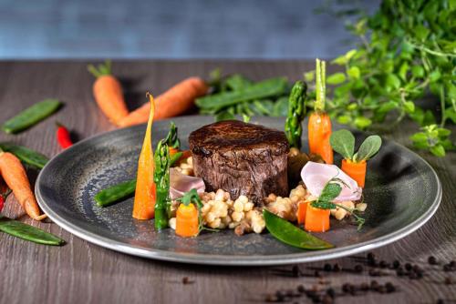 a plate of food with meat and vegetables on a table at Radisson Blu Hotel Bremen in Bremen