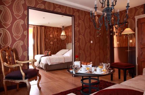 a room with a bed and a table and a mirror at Auberge A La Bonne Idée in Saint-Jean-aux-Bois