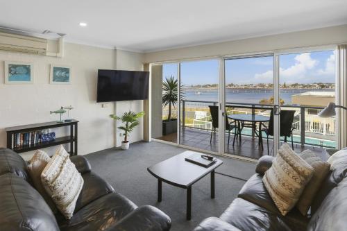 a living room with a couch and a view of the ocean at Crown Apartments in Merimbula