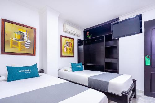 a hotel room with two beds and a flat screen tv at Ayenda Union in Valledupar