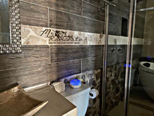 a bathroom with a toilet and a sign on the wall at Mi Ranchito Chignahuapan Hotel in Chignahuapan