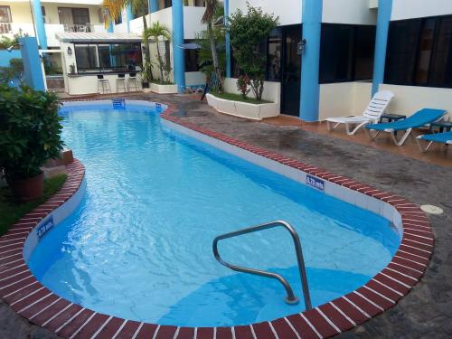 a large blue swimming pool in front of a building at Apartamentos in Condo Plaza Europa in Sosúa