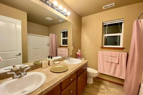 a bathroom with two sinks and a toilet and a mirror at B6-SERENE VILLA-Romantic get-away while WFH in Bothell