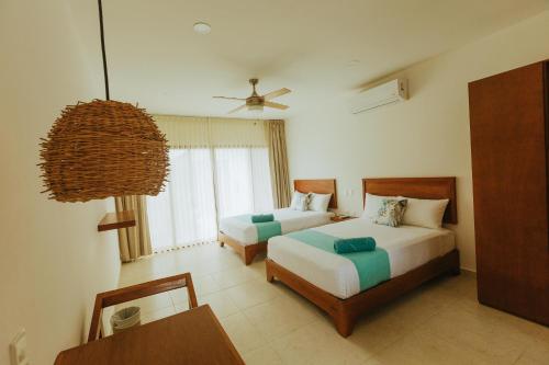 um quarto de hotel com duas camas e uma mesa em Hotel Boutique Naj Casa Holbox em Holbox