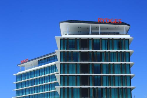a tall building with a rhodos sign on it at Rydges Gold Coast Airport in Gold Coast