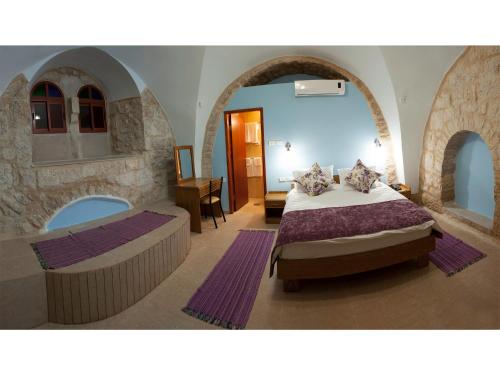 a bedroom with a bed and a tub in a room at Dar Sitti Aziza in Bethlehem
