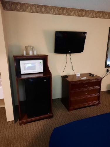 a room with a microwave and a tv on a cabinet at Horse Creek Inn in McCook