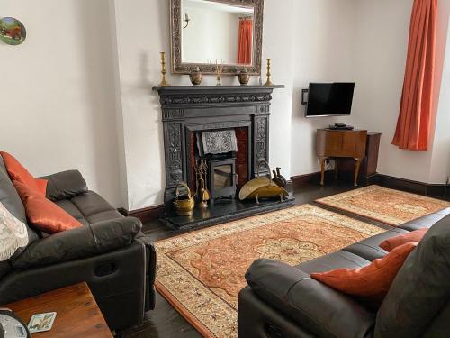 a living room with a fireplace and a mirror at Harbour Cottage in Watchet