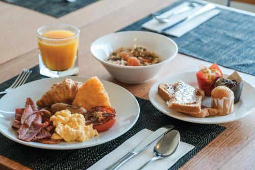 una mesa con dos platos de desayuno y un vaso de zumo de naranja en Crowne Plaza Perth by IHG, en Perth