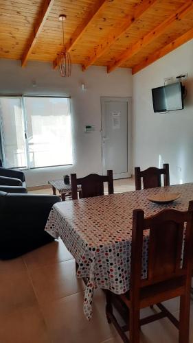 una sala da pranzo con tavolo, sedie e TV di ballena franca a Puerto Madryn