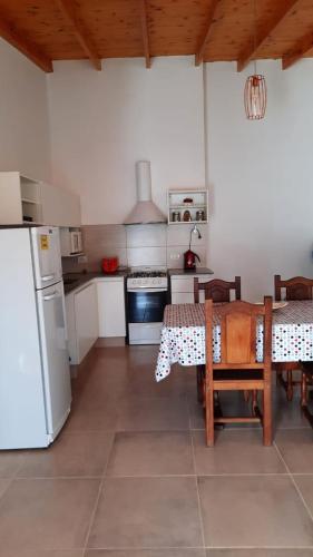 a kitchen with a table and a white refrigerator at ballena franca in Puerto Madryn