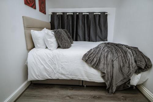 a bedroom with a bed with white sheets and pillows at Zest Apartment One in Manchester