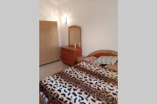 um quarto com uma cama, uma cómoda e um espelho em Appartement à louer à Hammamet nord em Hammamet