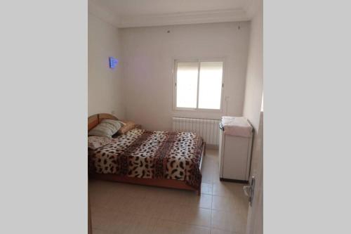 Appartement à louer à Hammamet nord في الحمامات: غرفة نوم بسرير ونافذة