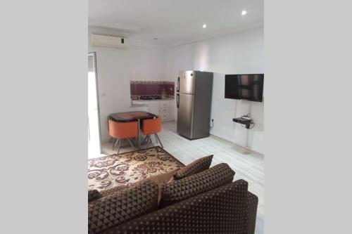 uma sala de estar com um sofá e um frigorífico em Appartement à louer à Hammamet nord em Hammamet