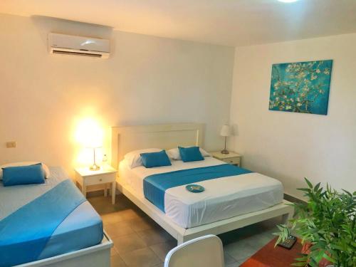 ein Schlafzimmer mit zwei Betten mit blauen Kissen in der Unterkunft RELAX STUDIES DELUXE SOL CARIBE in Punta Cana