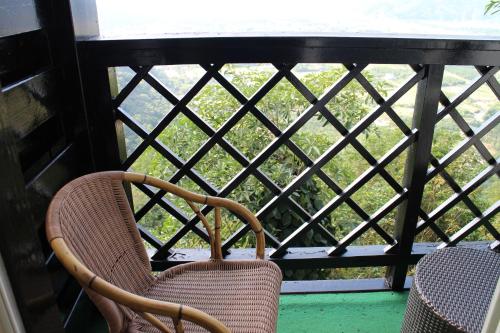 a pair of chairs sitting on a balcony looking out a window at Shangrila Leisure Farm in Dongshan