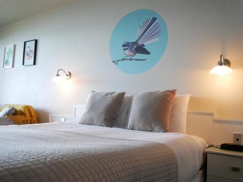 a bedroom with a bed with a bird on the wall at Boulevard Waters in Taupo