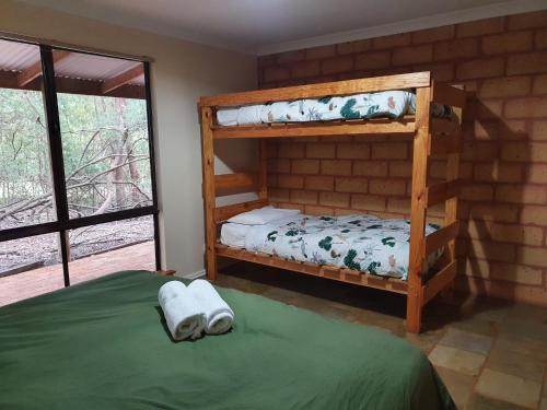 a bedroom with two bunk beds and a window at Little River Farm Cottages in Denmark
