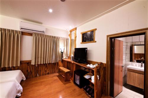 a hotel room with a bed and a television at Shangrila Leisure Farm in Dongshan