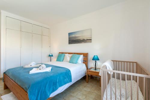 a bedroom with a large bed with blue sheets at Vitamin Sea - Contemporary Beach Villa with heated pool in Altura