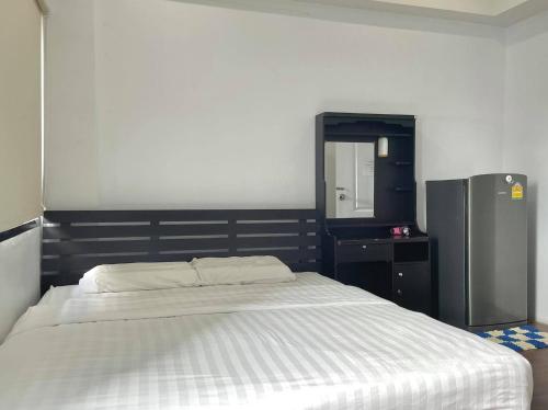 a bedroom with a large bed and a refrigerator at Bake Room Hostel in Chiang Mai