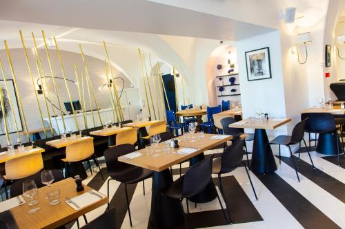 a dining room with wooden tables and chairs at The Originals Boutique, Hôtel Le Lion, Clermont-Ferrand in Clermont-Ferrand