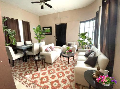 a living room with white furniture and a piano at La casa del colibrí in Campeche