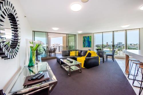 a living room with a couch and a table at Lanai Riverside Apartments in Mackay