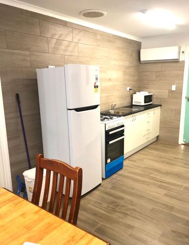 a kitchen with a white refrigerator and a table at Bay Lodge in Denham