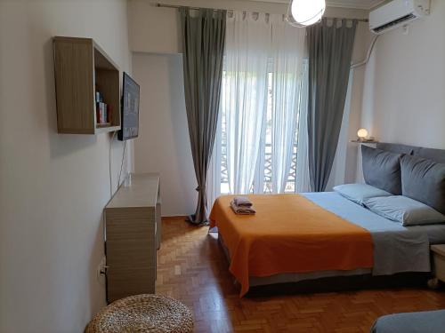 a bedroom with a bed and a couch and a window at Pagrati Park in Athens