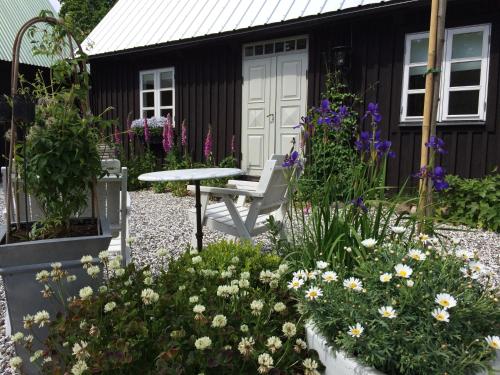 einen Garten mit einer Bank und Blumen vor einem Haus in der Unterkunft Flickebäck in Förslöv