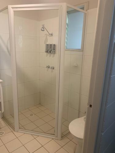 a bathroom with a shower and a toilet at Lake Munmorah Motel in Lake Munmorah