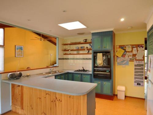 a kitchen with blue cabinets and a counter top at Beechwood Surf Side in Inverloch