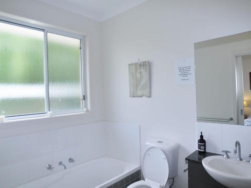 a white bathroom with a sink and a toilet at Sandpiper 3 Close To Beach And Town in Inverloch