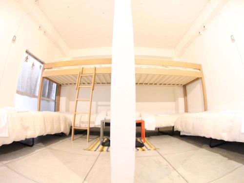 a room with a bunch of beds in it at ROUTE - Cafe and Petit Hostel in Nagasaki