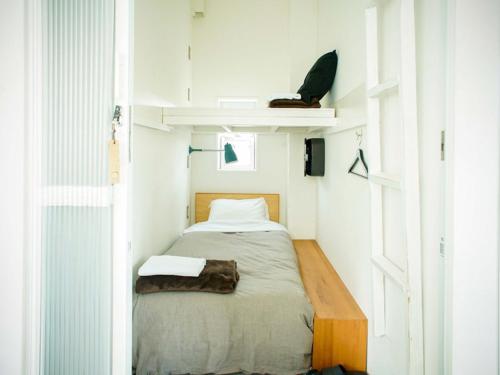 a small bedroom with a bed in a room at ROUTE - Cafe and Petit Hostel in Nagasaki
