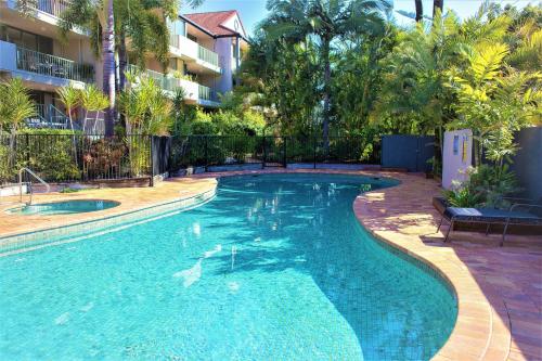 a swimming pool in a resort with trees and a building at Montana Palms Resort in Gold Coast