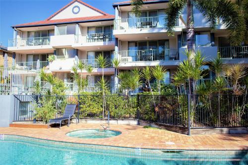 a building with a chair next to a swimming pool at Montana Palms Resort in Gold Coast