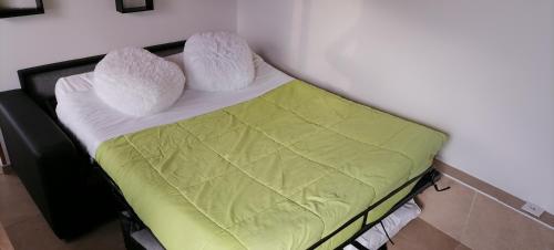 - un petit lit avec 2 oreillers dans l'établissement Petite maison, à Lourdes