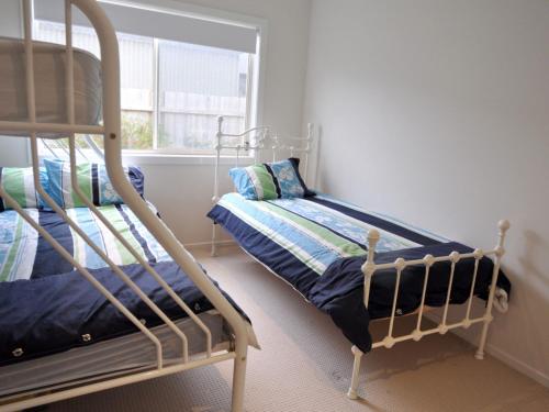 a bedroom with a bunk bed and a window at The Haven in Inverloch