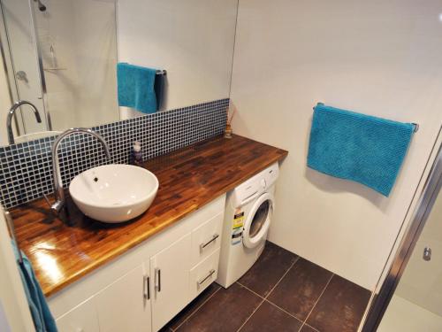 een badkamer met een wastafel en een wasmachine bij Waves on Florida in Inverloch