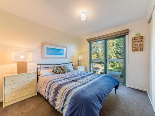 um quarto com uma cama e uma janela em Woodingdean em Inverloch